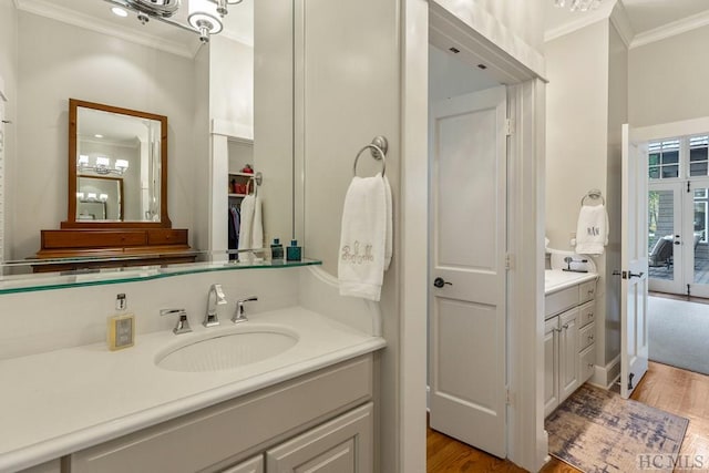 bathroom featuring vanity, crown molding, and wood-type flooring