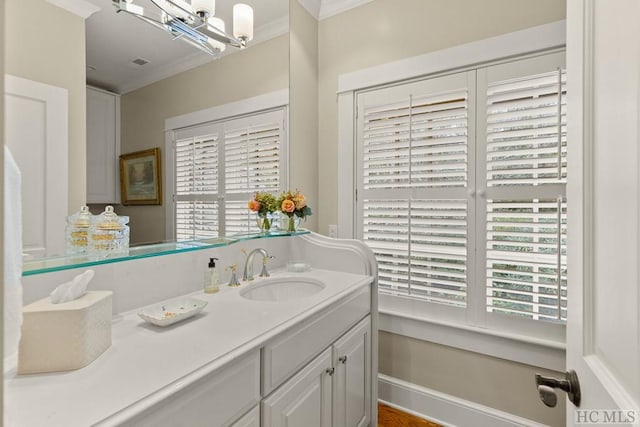 bathroom with ornamental molding, vanity, and an inviting chandelier