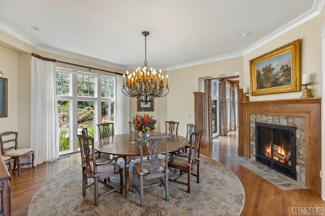 dining area with crown molding, a fireplace, a chandelier, and wood-type flooring