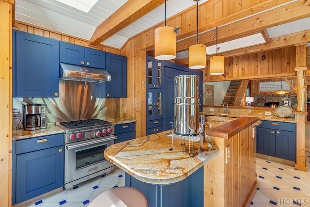 kitchen featuring pendant lighting, wooden walls, a kitchen breakfast bar, kitchen peninsula, and luxury range