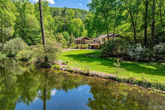 view of property's community with a lawn and a water view