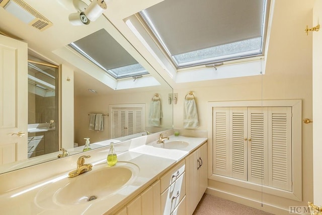 bathroom with vanity, toilet, and a skylight