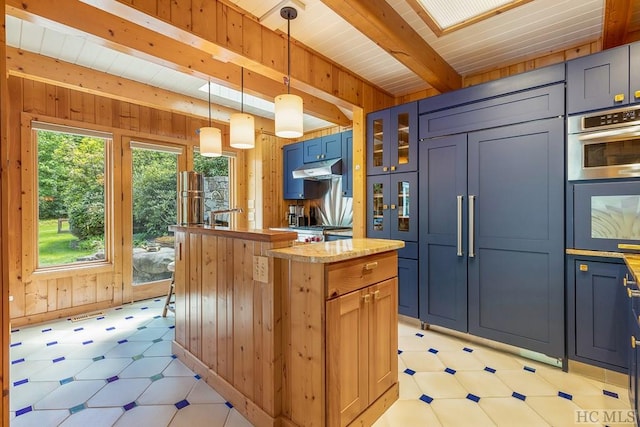 kitchen with wooden walls, hanging light fixtures, wood ceiling, blue cabinetry, and beam ceiling