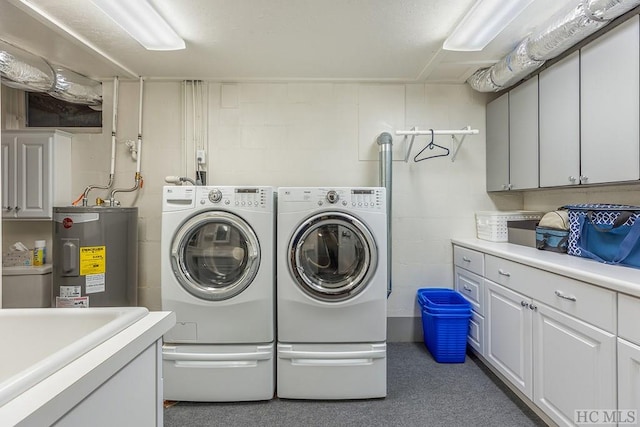 1213 Bull Pen Rd, Cashiers, NC 28717 - laundry area featuring cabinet space, concrete block wall, water heater, and washing machine and clothes dryer