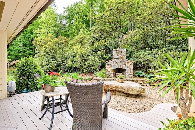 wooden terrace with an outdoor stone fireplace