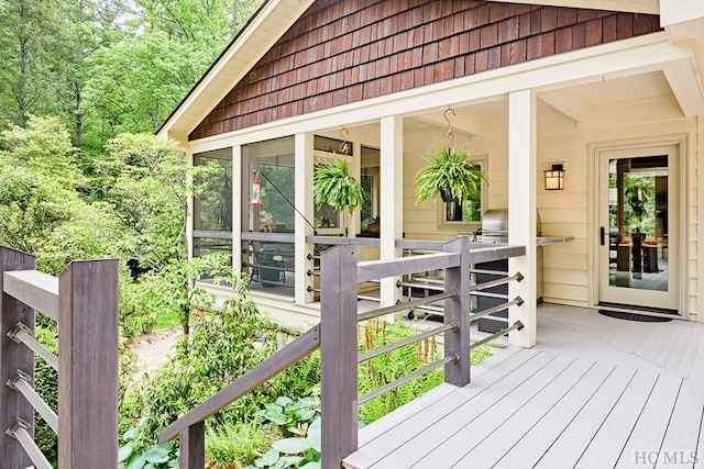 wooden terrace featuring area for grilling and a sunroom