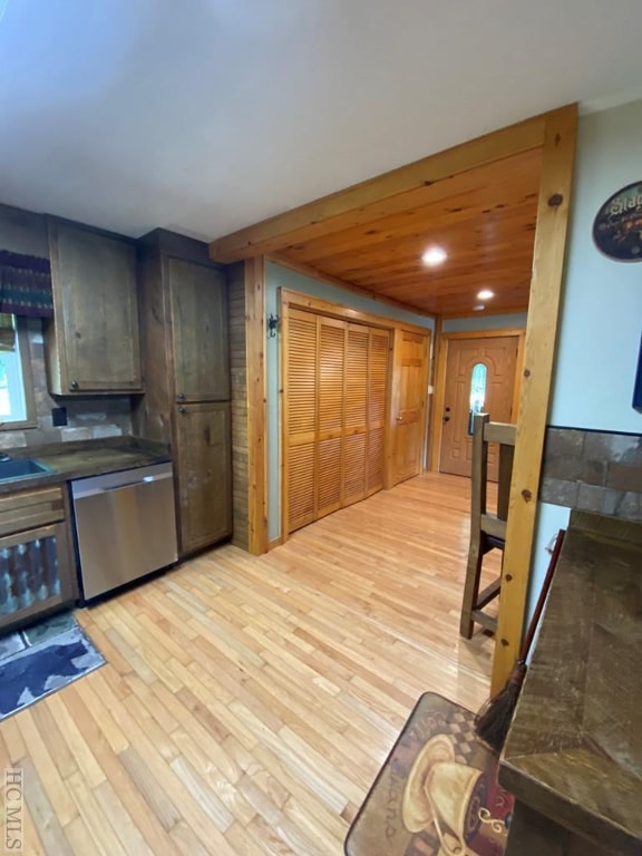 kitchen featuring stainless steel dishwasher, wooden ceiling, sink, and light wood-type flooring