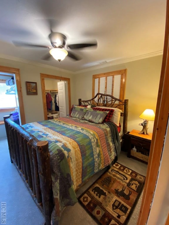 bedroom featuring ceiling fan, ornamental molding, carpet flooring, and a closet