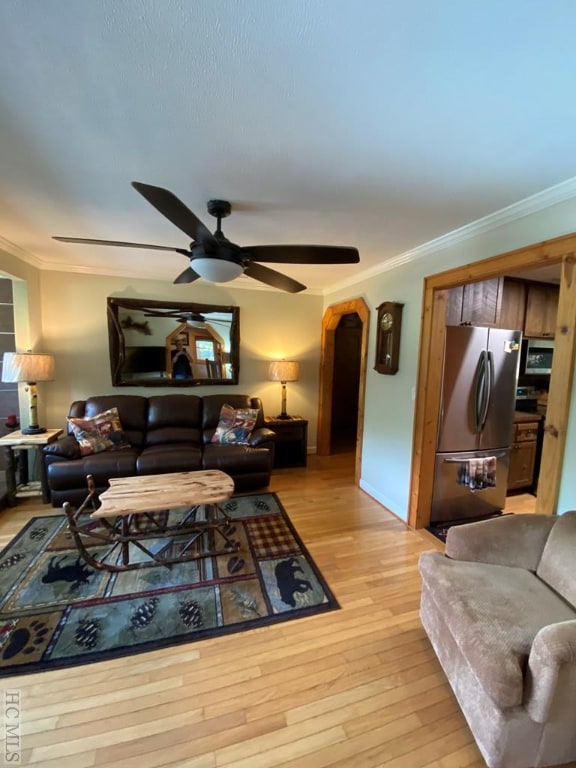 living room with ornamental molding, ceiling fan, and light hardwood / wood-style floors