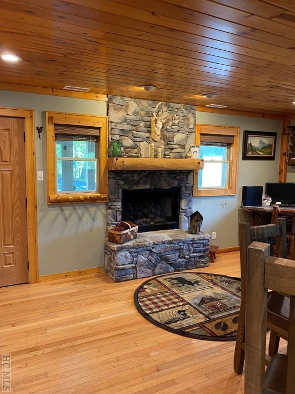 living room featuring hardwood / wood-style floors, wooden ceiling, and a fireplace