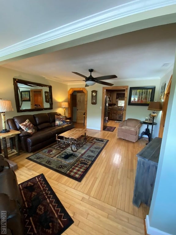 living room with hardwood / wood-style flooring, crown molding, and ceiling fan