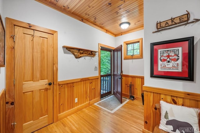 foyer entrance featuring hardwood / wood-style floors, wood ceiling, and ornamental molding