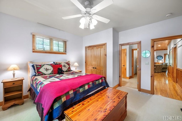 bedroom featuring light colored carpet, a closet, and ceiling fan