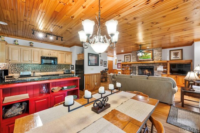 dining room featuring a large fireplace, wooden ceiling, rail lighting, and light wood-type flooring