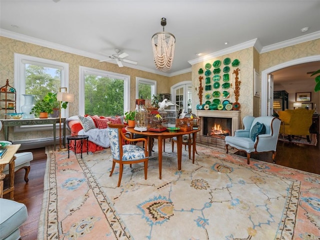 13084 Canada Rd, Tuckasegee, NC 28783 - dining space featuring a warm lit fireplace, wood finished floors, wallpapered walls, crown molding, and a chandelier