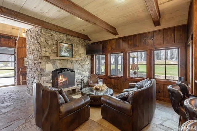 living room with wood ceiling, a fireplace, beamed ceiling, and wood walls