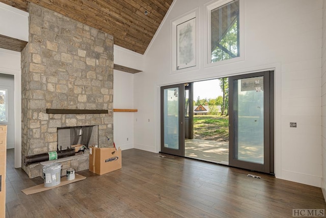 unfurnished living room featuring dark wood-type flooring, a fireplace, high vaulted ceiling, and wooden ceiling