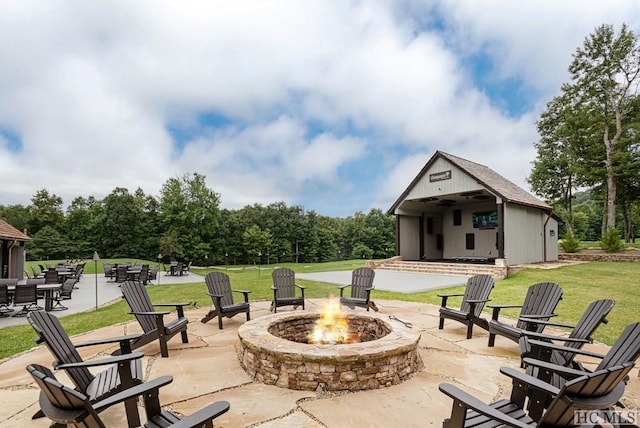 view of patio with an outdoor structure and a fire pit