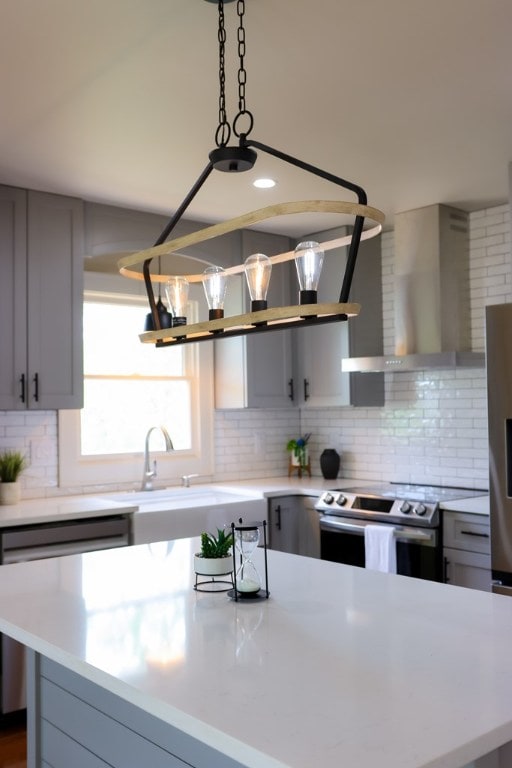 94 Breezy Knob Rd, Franklin, NC 28734 - kitchen with wall chimney exhaust hood, appliances with stainless steel finishes, gray cabinetry, and light countertops