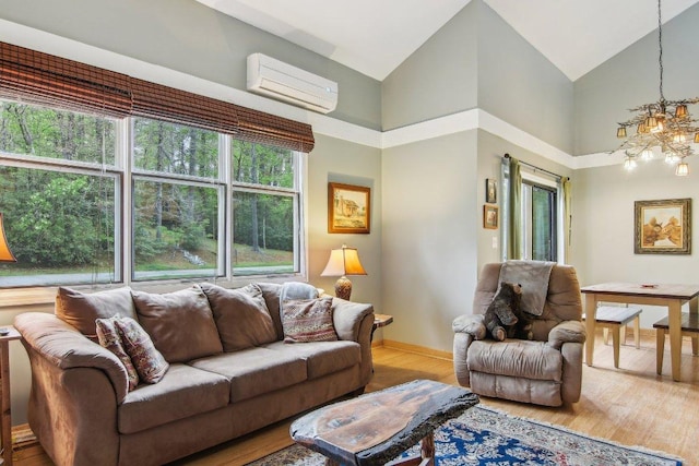 living area featuring a wall mounted air conditioner, wood finished floors, high vaulted ceiling, an inviting chandelier, and baseboards