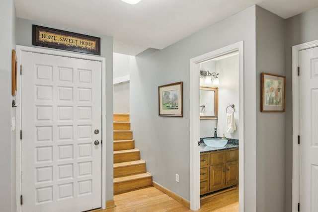 foyer with light wood-style floors, stairway, and baseboards