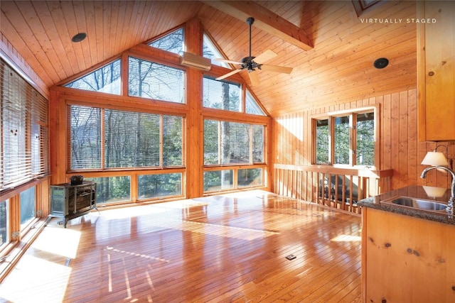 334 Back Nine Ln, Sapphire, NC 28774 - unfurnished living room with high vaulted ceiling, a wood stove, healthy amount of natural light, wood walls, and hardwood / wood-style floors