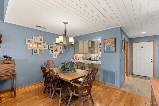 dining area featuring crown molding, a notable chandelier, wooden ceiling, and light wood-type flooring