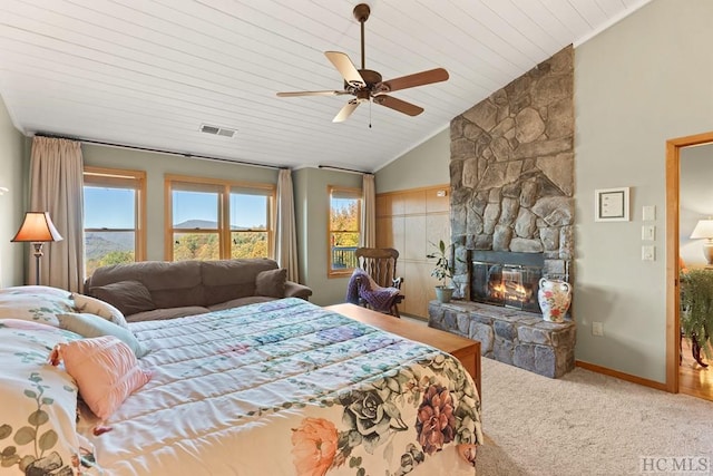 carpeted bedroom with lofted ceiling, wood ceiling, a stone fireplace, and ceiling fan