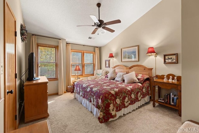 bedroom featuring lofted ceiling, a textured ceiling, light carpet, and ceiling fan