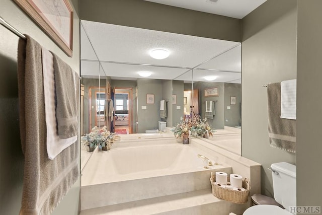 bathroom featuring toilet and a tub to relax in