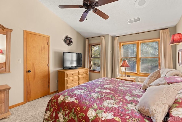 bedroom featuring lofted ceiling, a textured ceiling, light colored carpet, and ceiling fan