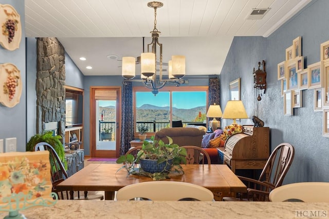 dining space featuring an inviting chandelier, wood ceiling, and a mountain view