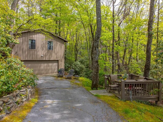 515 Stillmont Cir, Cashiers, NC 28717 - view of home's exterior with driveway, an attached garage, board and batten siding, and a view of trees