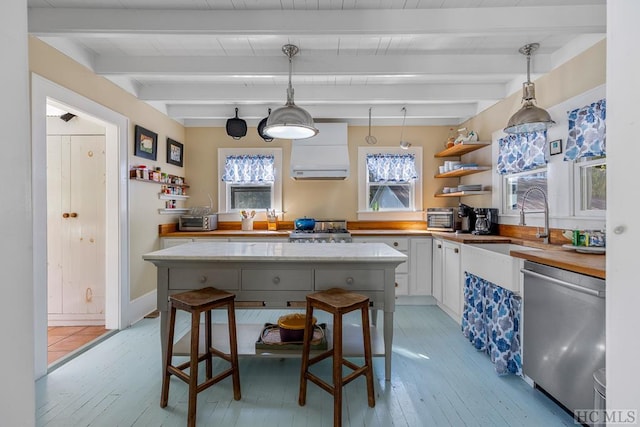 kitchen with a kitchen bar, white cabinetry, hanging light fixtures, stainless steel dishwasher, and beamed ceiling