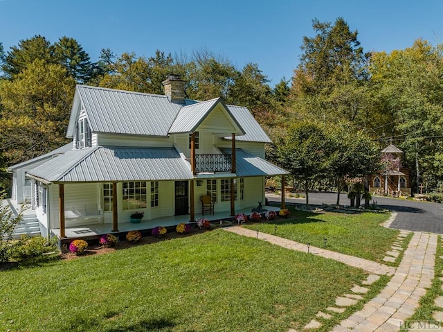 view of front of house with a porch, a balcony, and a front yard