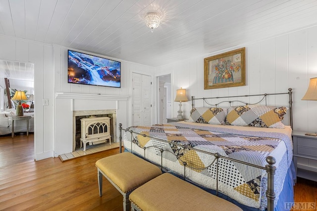 bedroom featuring wood ceiling, hardwood / wood-style flooring, and wooden walls