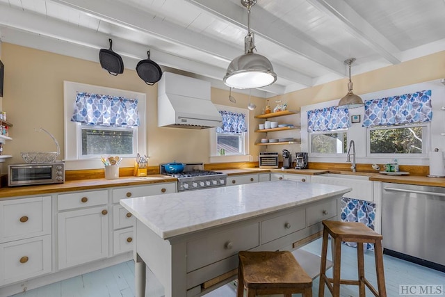 kitchen with white cabinetry, stove, stainless steel dishwasher, custom range hood, and beam ceiling