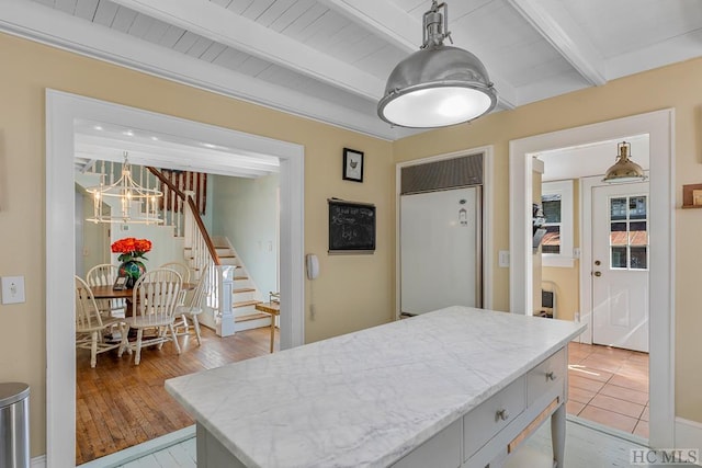 kitchen with beamed ceiling, a chandelier, light hardwood / wood-style flooring, paneled refrigerator, and pendant lighting