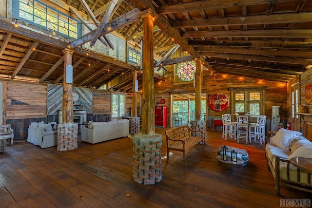 unfurnished living room with wood ceiling, dark hardwood / wood-style flooring, high vaulted ceiling, and wood walls