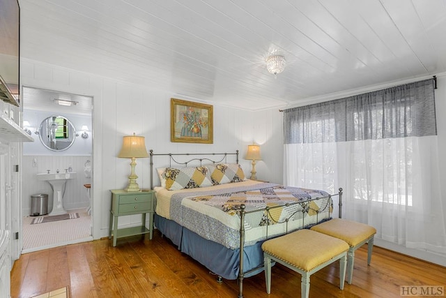 bedroom with hardwood / wood-style floors, wood ceiling, ornamental molding, and sink