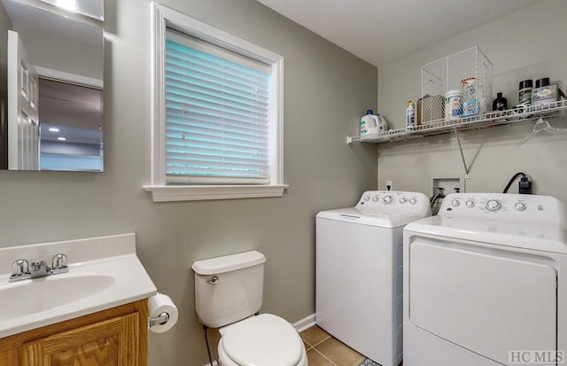 laundry area with sink, light tile patterned floors, and washer and clothes dryer