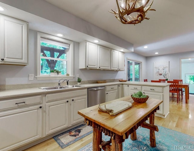 kitchen with sink, dishwasher, white cabinets, and light wood-type flooring