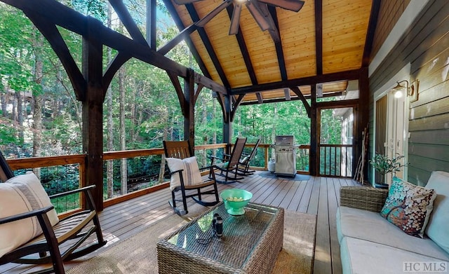 sunroom / solarium with vaulted ceiling with beams, wood ceiling, plenty of natural light, and ceiling fan