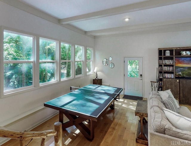 recreation room featuring beam ceiling and light hardwood / wood-style flooring