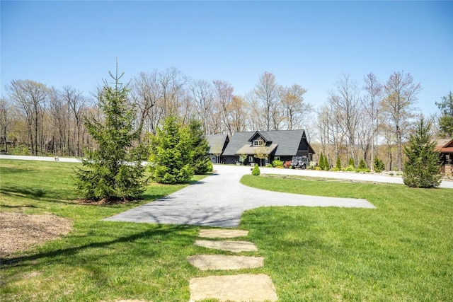 view of home's community with a lawn and aphalt driveway