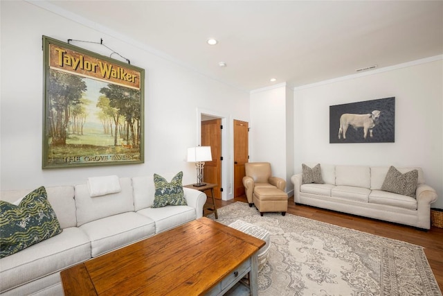 living area with visible vents, ornamental molding, wood finished floors, and recessed lighting