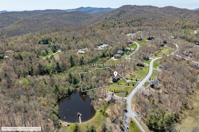 bird's eye view with a water and mountain view and a wooded view