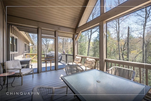 sunroom / solarium featuring outdoor dining area and a healthy amount of sunlight
