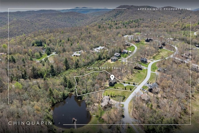 drone / aerial view with a forest view and a water and mountain view