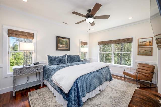bedroom with baseboards, a ceiling fan, wood finished floors, and visible vents